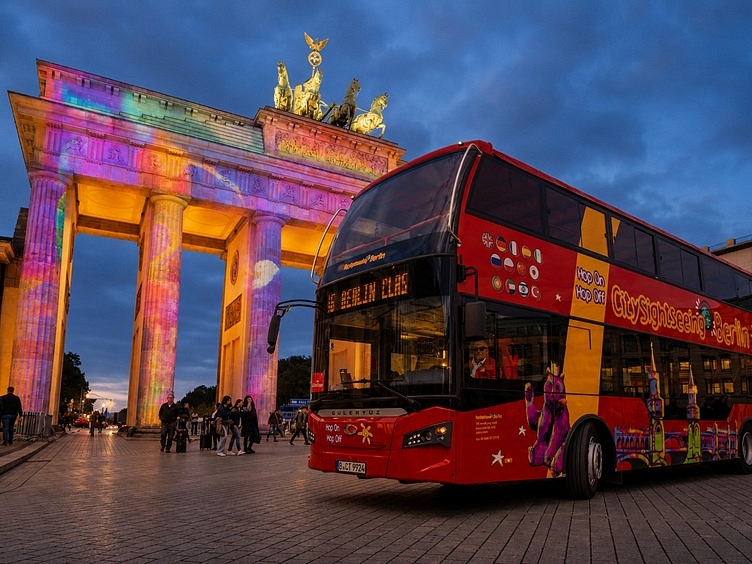 Berlin Tour of Lights City Sightseeing bus in front of brandenburger tor horizontal crop