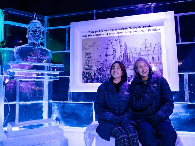 Icebar Berlin girls sitting down inside the icebar next to a sculpture 752x564